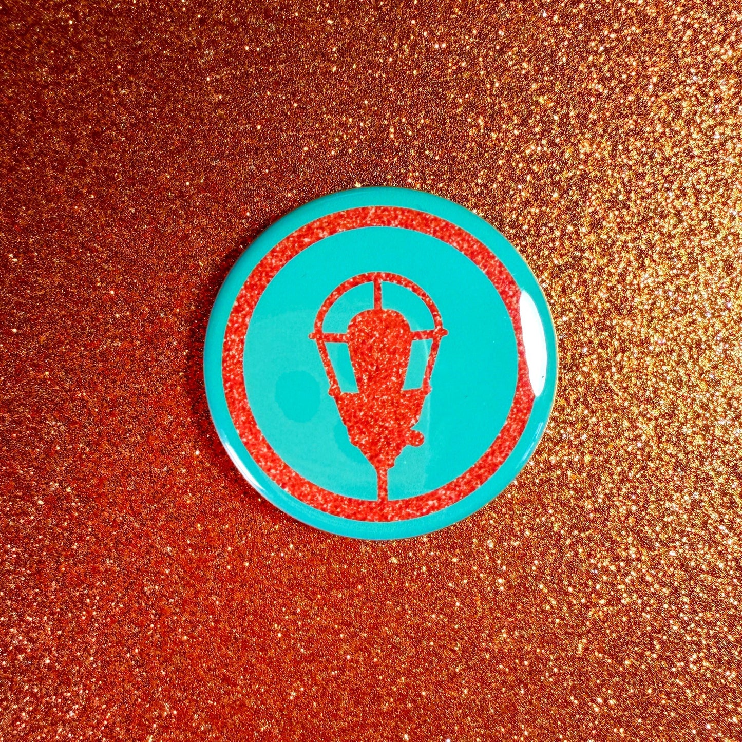 Circular badge with a design on a glittery brown background