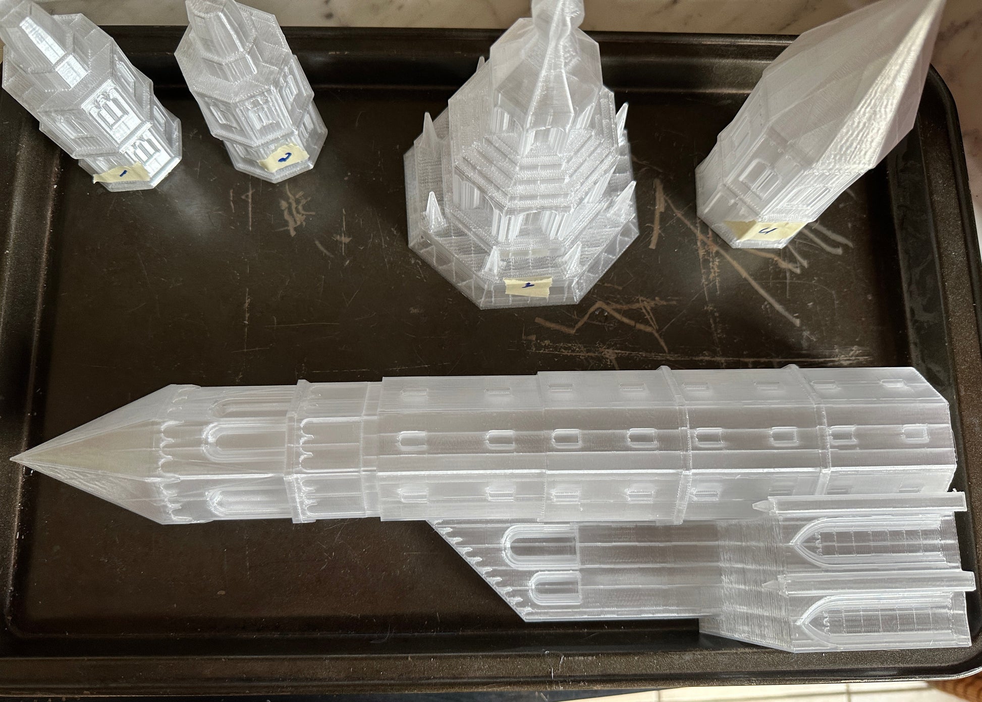 Clear plastic models of buildings on a dark surface