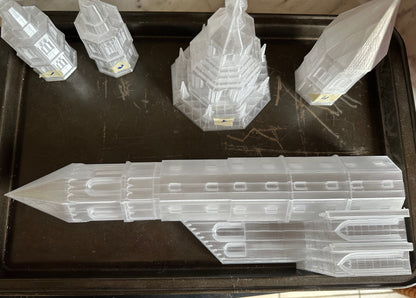 Clear plastic models of buildings on a dark surface