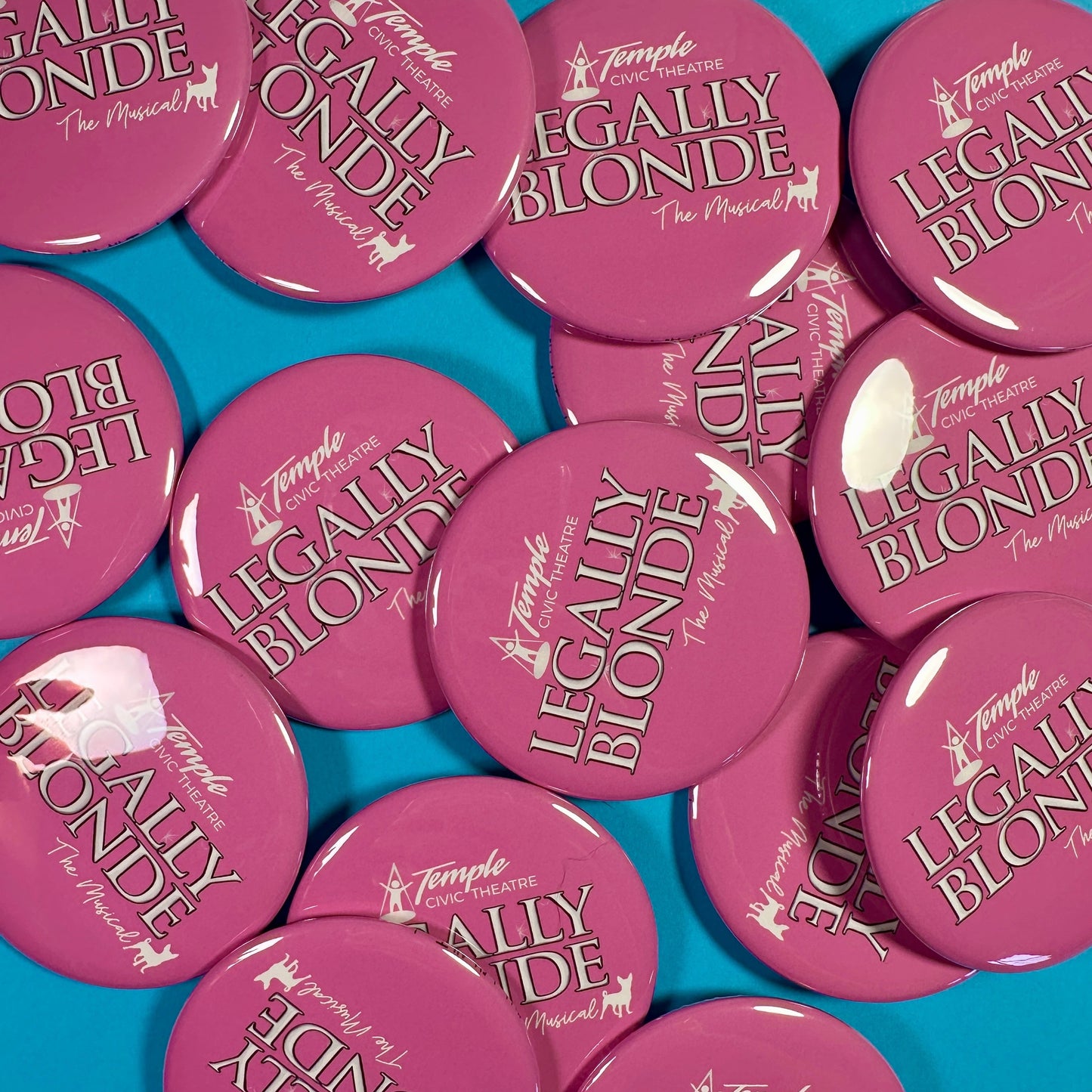 Pink buttons with 'Legally Blonde' text on a blue background