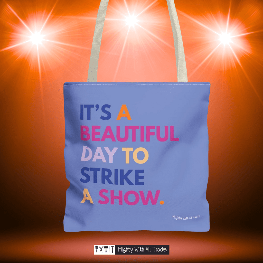 Purple tote bag with it's a beautiful day to strike a show colorful text on a bright orange background
