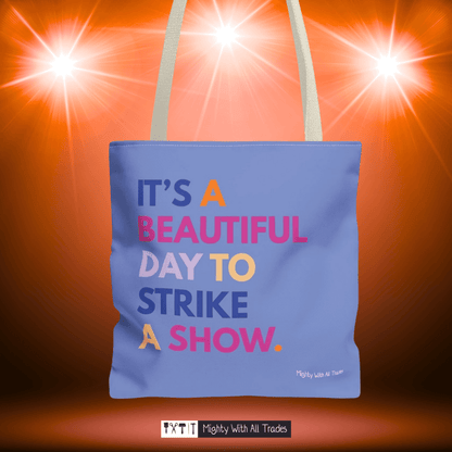 Purple tote bag with it's a beautiful day to strike a show colorful text on a bright orange background