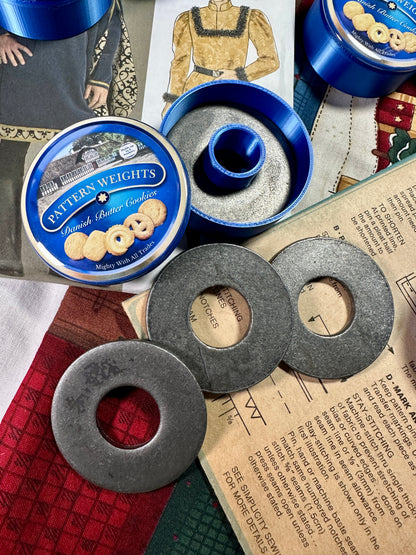 Metal weights with blue containers labeled 'Patterson's Weights' on a textured surface.