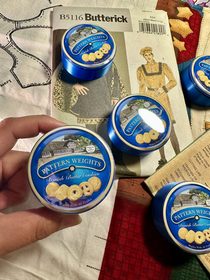 Butterick pattern with cookie weights and a hand holding one of the weights.