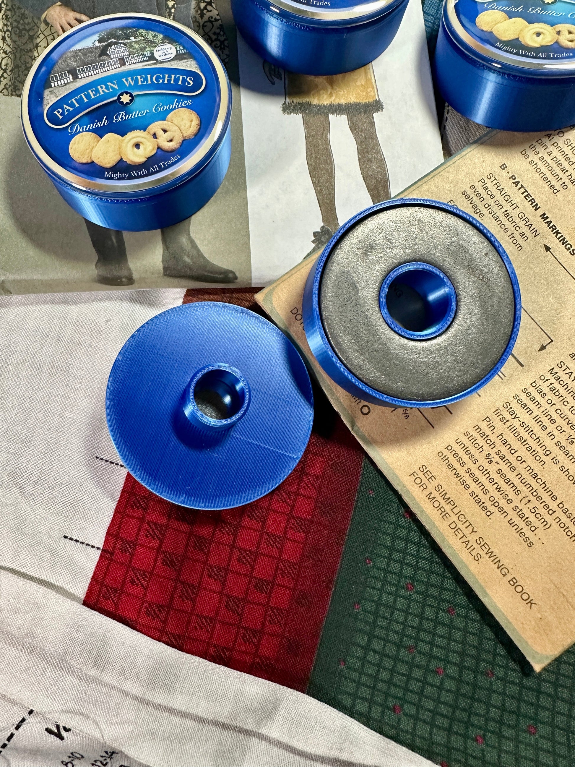 Blue pattern weights with a lid on a surface with printed material underneath