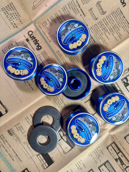 Set of blue tins with circular objects on a newspaper background