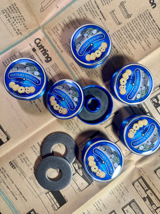 Set of blue tins with circular objects on a newspaper background