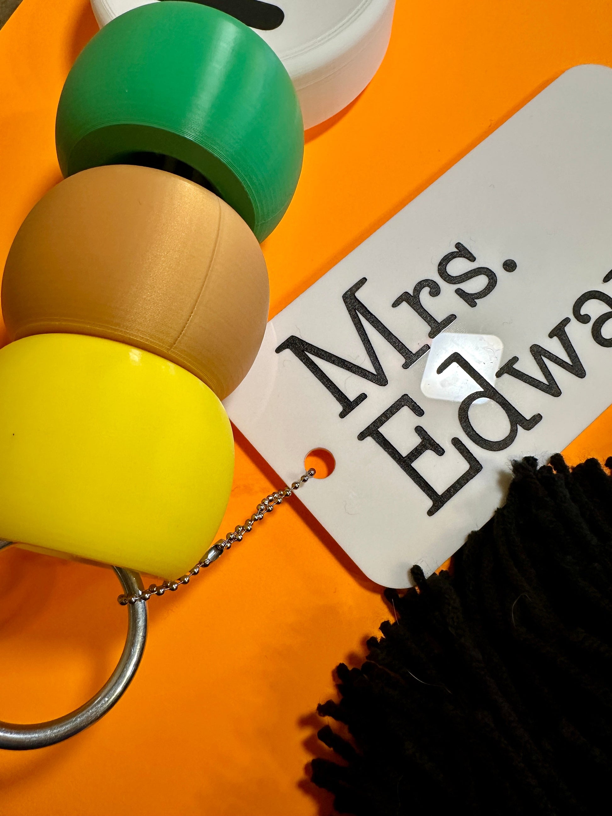 Colorful keychain with a tag labeled 'Mrs. Edward' on an orange background