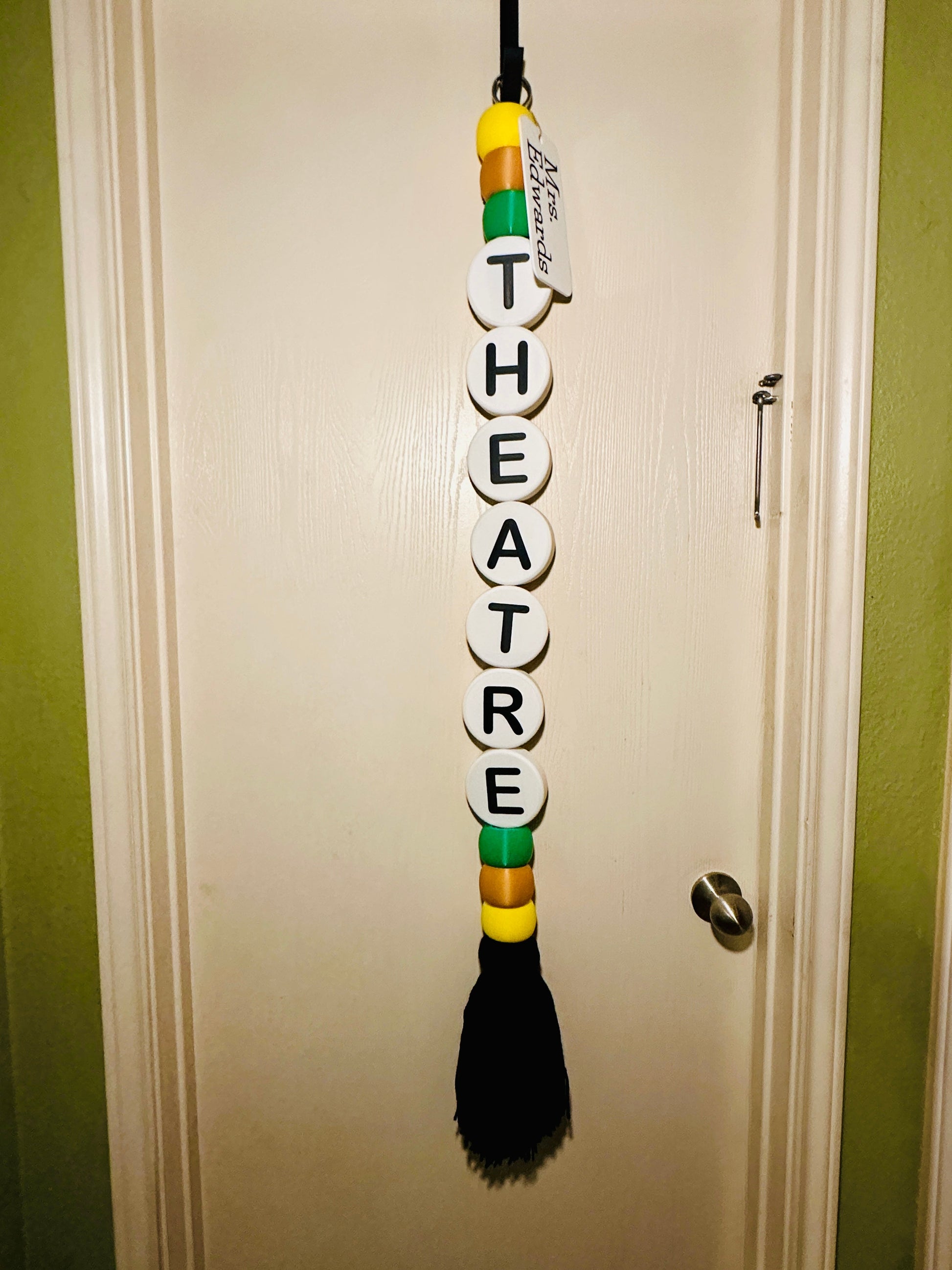 Decorative wall hanger with 'THEATRE' spelled out on a door