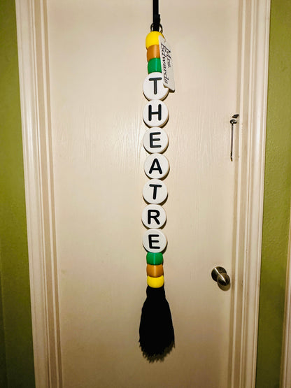 Decorative wall hanger with 'THEATRE' spelled out on a door