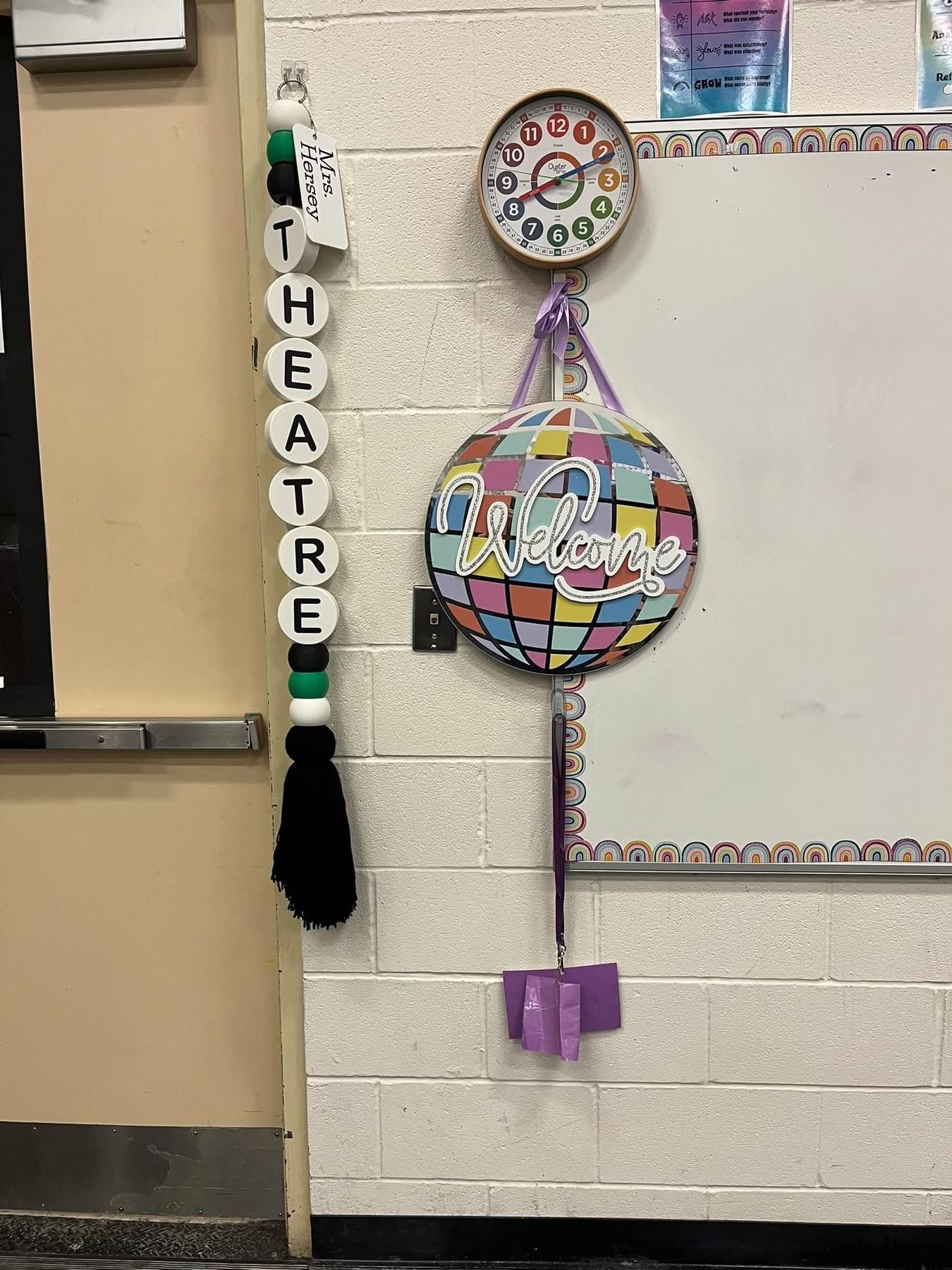 Decorative items on a classroom door, including a 'Theatre Welcome' sign and colorful ball.