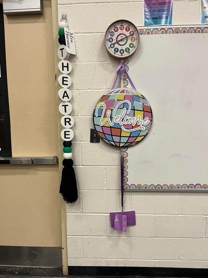 Decorative items on a classroom door, including a 'Theatre Welcome' sign and colorful ball.