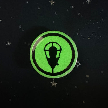 Green circular glow-in-the-dark sticker with a black lamp design on a dark background.