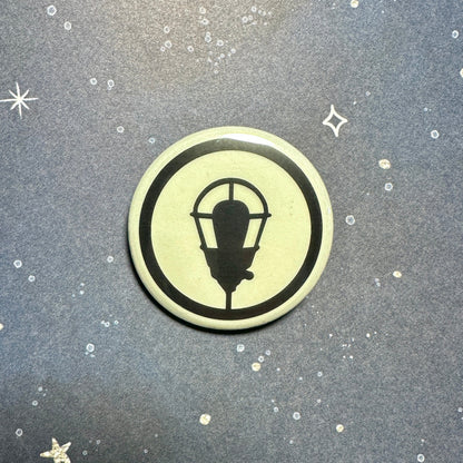 Glowing button with a black lamp design on a textured gray background with star shapes.