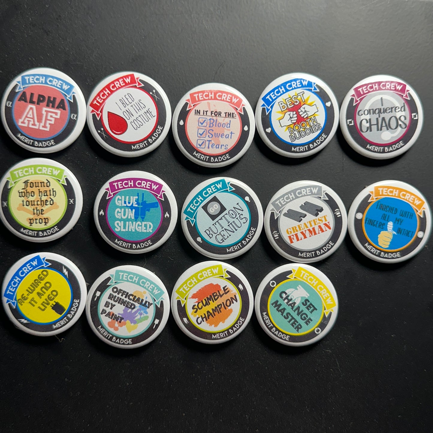 collection of tech crew buttons on a black background